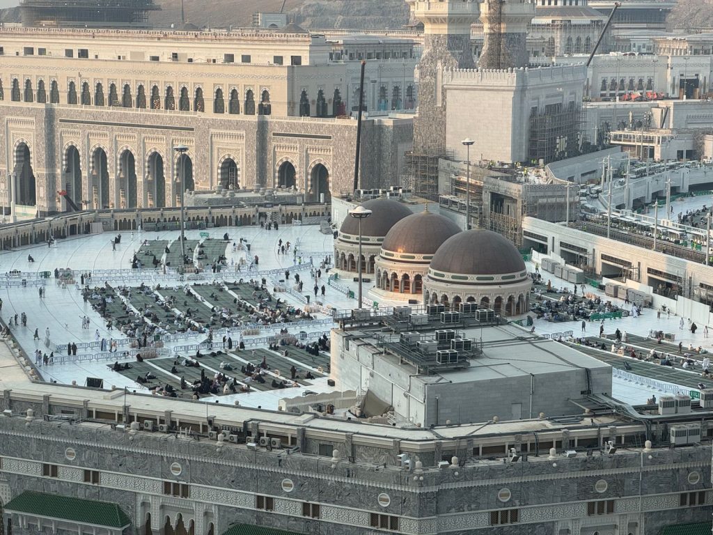 Aerial shot of Masjid al-Haram in Mecca, showcasing architecture and pilgrims.